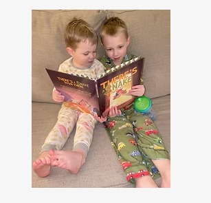 Two boys reading the book together